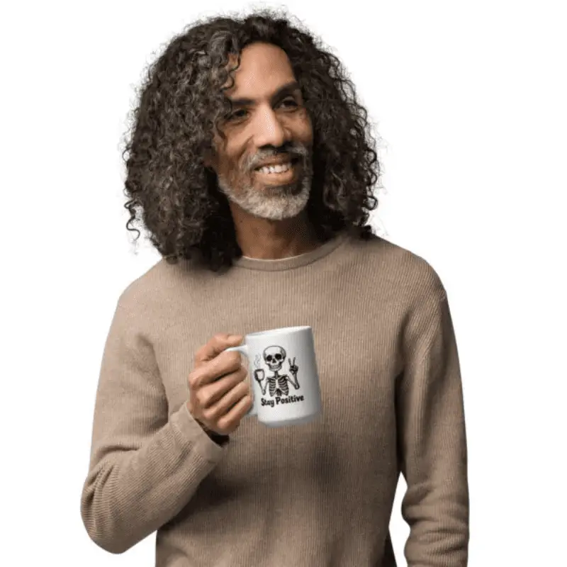 homme tenant en main une tasse à café imprimé " stay positive"