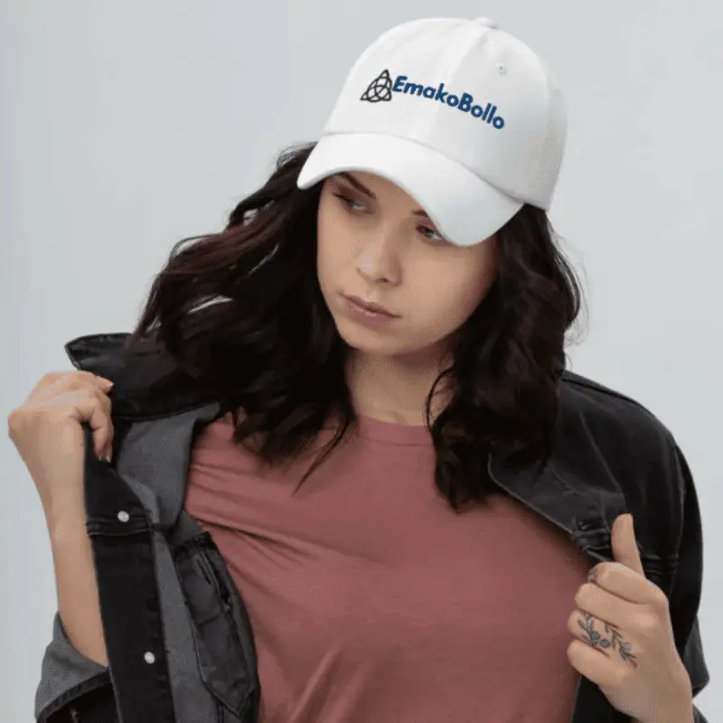 femme avec un t-shirt et un blouson noir arborant une Casquette brodée personnalisée EmakoBollo blanche