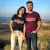 couple souriant, se tenant la main, portant chacun le t-shirt Colorado, avec un paysage de campagne en arrière-plan.