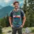 jeune homme souriant, torse à trois-quarts, portant le t-shirt Colorado lors d'une randonnée en montagne.