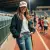 Photo : femme souriante portant une casquette de baseball kaki "love", lors d'un événement sportif,