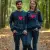 Un homme et une femme d'âge moyen, enlacés, portant des sweats "I love you" (un navy blazer, un charcoal heather) lors d'une promenade en forêt. Lumière naturelle, émotion de tendresse.