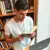 Photo : Un jeune homme concentré sur ses livres, le mug posé à côté de son ordinateur portable
