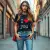 Une femme stylée portant le t-shirt love you avec un jean et des baskets, dans un environnement urbain, mettant en avant la coupe et le design.