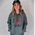 Une jeune femme souriante, portant le sweat "I love you" couleur carbon grey, avec des accessoires tendance (casquette, jean). Photo de profil, expression de confiance