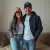 Photo : femme et homme souriante portant chacun une casquette de baseball kaki et noir "love", assis sur le canapé