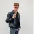 un jeune homme avec un style décontracté, montrant sa coque sur son téléphone, avec une tasse de café similaire au design